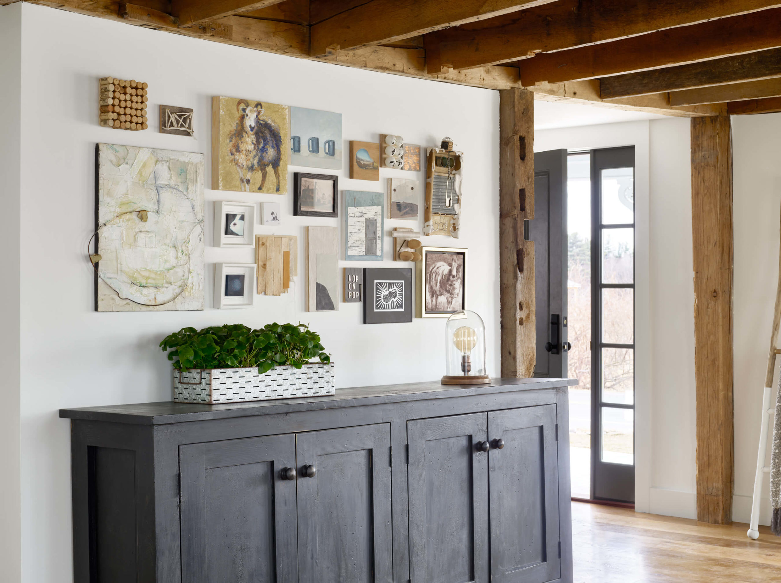 Farmhouse interior, art wall, gallery wall, family room design, art curation, local artists, ceiling beams, reclaimed beams, exposed wood ceiling, reclaimed posts, living room interior design, family room interior design, farmhouse designs, black cabinet, Kristina Crestin , Kristina Crestin Design, HGTV Farmhouse Fixer, HGTV Farmhouse