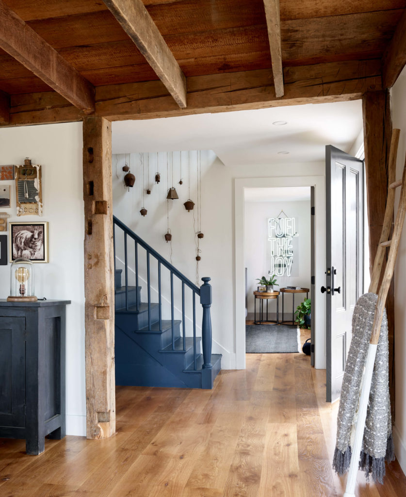 Farmhouse interior, art wall, gallery wall, art curation, local artists, living room interior design, family room interior design, farmhouse designs, modern farmhouse entry, modern farmhouse foyer, farmhouse entry, farmhouse foyer, reclaimed wood ceiling, exposed beam ceiling, exposed joists ceiling, reclaimed posts, blue stairs, blue staircase, blue painted stair